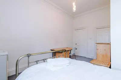 a white bedroom with a bed and a desk at Escowbeck House - Staycation - HotTub - Sleeps 10 in Caton