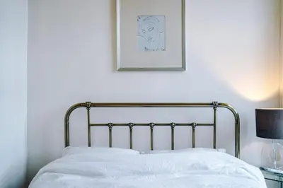 a bed in a bedroom with a picture on the wall at Escowbeck House - Staycation - HotTub - Sleeps 10 in Caton