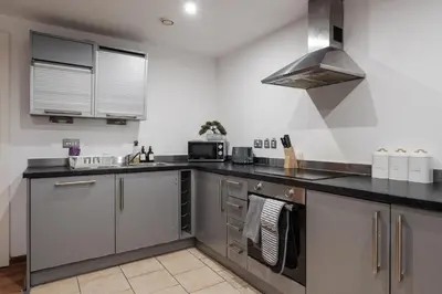a kitchen with stainless steel cabinets and a sink at Premium 10-Room Contractor Accommodation Central Location in Liverpool