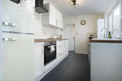 a kitchen with white cabinets and a sink at Three Bridges - 1-Mile from Ulverston Town Centre in Ulverston