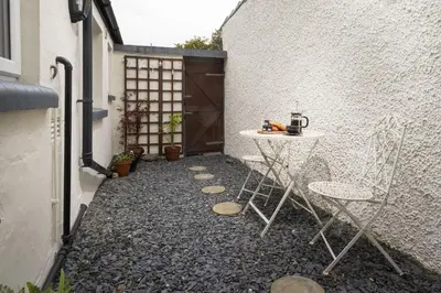 a patio with a table and chairs in a courtyard at Three Bridges - 1-Mile from Ulverston Town Centre in Ulverston