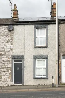 a brick house with two windows and a door at Three Bridges - 1-Mile from Ulverston Town Centre in Ulverston