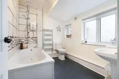 a white bathroom with a sink and a toilet at Three Bridges - 1-Mile from Ulverston Town Centre in Ulverston