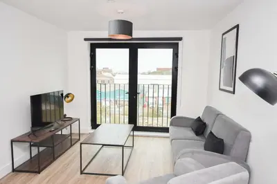 a living room with a couch and a television at Fabulous Modern 2 Bedroom Apartment in Liverpool in Liverpool