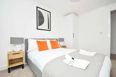 a bedroom with two beds with orange and white pillows at Fabulous Modern 2 Bedroom Apartment in Liverpool in Liverpool
