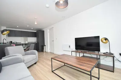 a living room with a couch and a table with a tv at Fabulous Modern 2 Bedroom Apartment in Liverpool in Liverpool