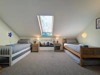 a attic bedroom with two beds and a skylight at Large 3-Bedrooms House Near Centre Free Parking in Liverpool