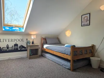 a bedroom with a wooden bed and a window at Large 3-Bedrooms House Near Centre Free Parking in Liverpool