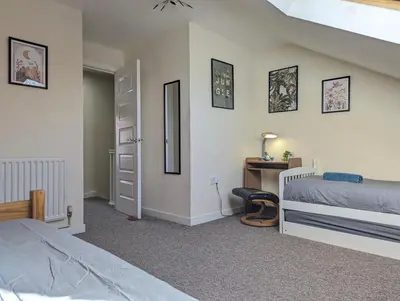 a bedroom with two beds and a desk with a mirror at Large 3-Bedrooms House Near Centre Free Parking in Liverpool