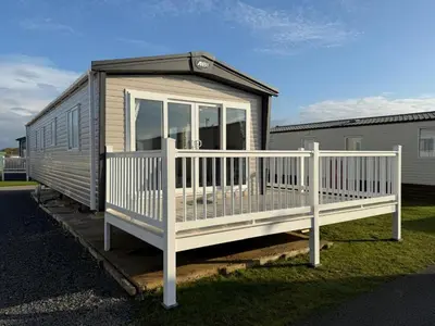 a tiny house with a porch and a white railing at The Retreat LD 1A Oceans Edge in Morecambe