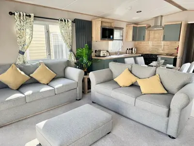 a living room with two couches and a kitchen at The Retreat LD 1A Oceans Edge in Morecambe