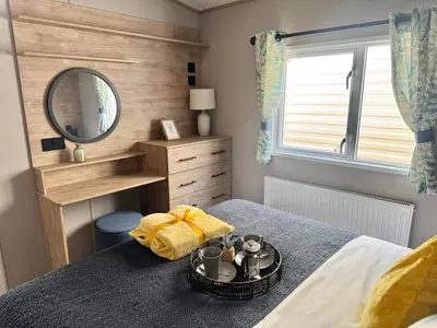 a small bedroom with a bed with a mirror at The Retreat LD 1A Oceans Edge in Morecambe