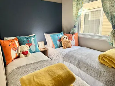 two beds with teddy bears sitting on them in a bedroom at The Retreat LD 1A Oceans Edge in Morecambe