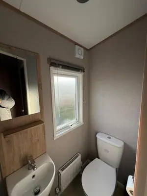 a bathroom with a toilet and a sink and a window at The Retreat LD 1A Oceans Edge in Morecambe