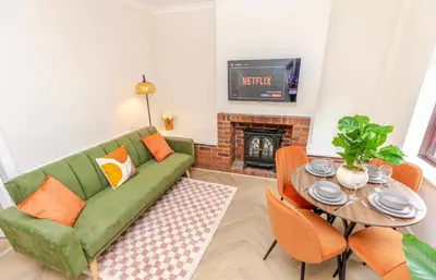 a living room with a green couch and a table at Cosy city centre home - Wi-Fi - Free Parking in Preston