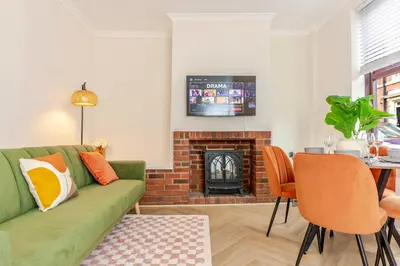 a living room with a green couch and a fireplace at Cosy city centre home - Wi-Fi - Free Parking in Preston