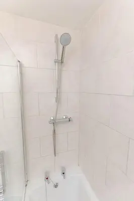 a white bathroom with a shower with a tub at Cosy city centre home - Wi-Fi - Free Parking in Preston
