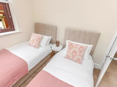 two beds sitting next to each other in a bedroom at Cosy city centre home - Wi-Fi - Free Parking in Preston