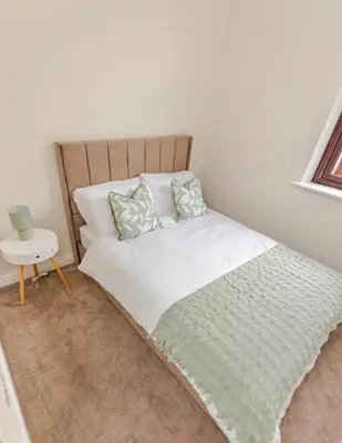 a bed with white sheets and pillows in a bedroom at Cosy city centre home - Wi-Fi - Free Parking in Preston