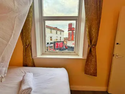 a bedroom with a window with a view of a city at Near City-Birkenhead rooms in Birkenhead