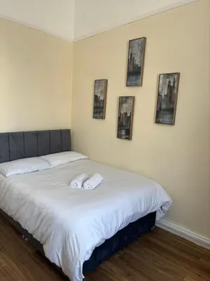 a bedroom with a bed with two towels on it at Near City-Birkenhead rooms in Birkenhead