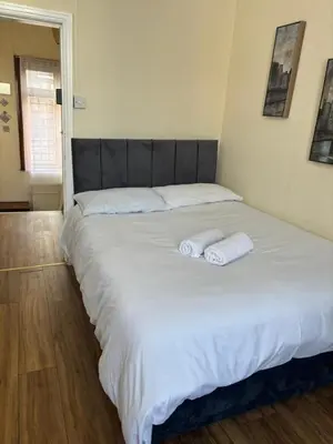 a large white bed with two towels on it at Near City-Birkenhead rooms in Birkenhead