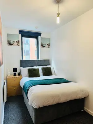 a bedroom with a large bed and a window at Longterm Stay City Centre Apartment 2 Bedrooms in Liverpool