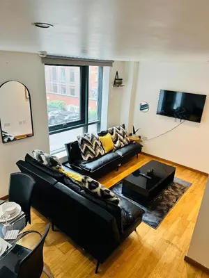 a living room with black leather furniture and a flat screen tv at Longterm Stay City Centre Apartment 2 Bedrooms in Liverpool