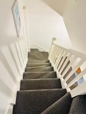 a staircase in a house with a picture on the wall at Longterm Stay City Centre Apartment 2 Bedrooms in Liverpool