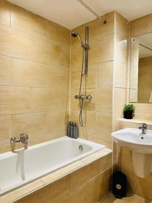 a bathroom with a bath tub and a sink at Longterm Stay City Centre Apartment 2 Bedrooms in Liverpool