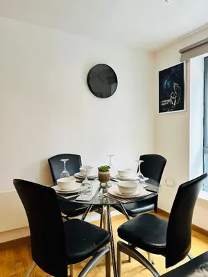 a dining room with a glass table and black chairs at Longterm Stay City Centre Apartment 2 Bedrooms in Liverpool