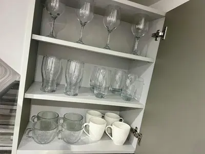 a bunch of glasses and cups on shelves at New Modern 3 Bed En-suites City Centre Apartment - Sleeps 8- Paid Parking Options in Preston