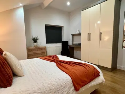 a bedroom with a large bed and a television at New Modern 3 Bed En-suites City Centre Apartment - Sleeps 8- Paid Parking Options in Preston