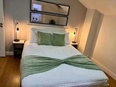 a bedroom with a bed with a green bow on it at New Modern 3 Bed En-suites City Centre Apartment - Sleeps 8- Paid Parking Options in Preston