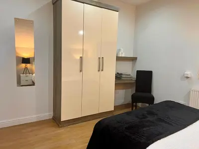 a bedroom with a large white cabinet next to a bed at New Modern 3 Bed En-suites City Centre Apartment - Sleeps 8- Paid Parking Options in Preston