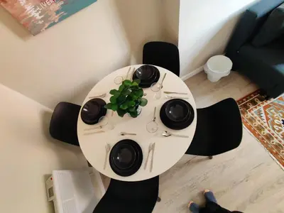 a white table with a plant on top of it at Victoria's Bright Georgian Apartment in Liverpool
