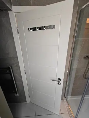 a white door in a bathroom with a shower at Victoria's Bright Georgian Apartment in Liverpool