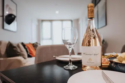 a bottle of wine sitting on a table with a glass at River Mersey Views Modern 2-Bed Waterfront Flat Near Albert Dock in Liverpool