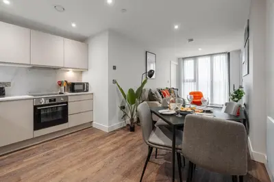 a kitchen and dining room with a table and chairs at River Mersey Views Modern 2-Bed Waterfront Flat Near Albert Dock in Liverpool