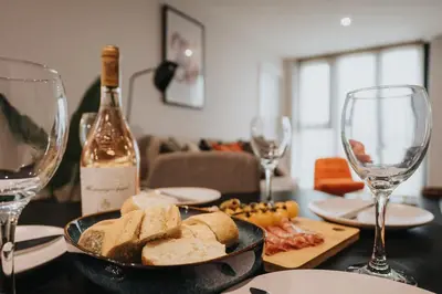 a table with a plate of bread and wine glasses at River Mersey Views Modern 2-Bed Waterfront Flat Near Albert Dock in Liverpool