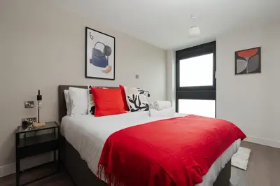 a bedroom with a large bed with a red blanket at River Mersey Views Modern 2-Bed Waterfront Flat Near Albert Dock in Liverpool