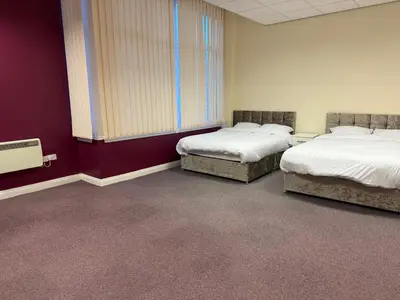 two beds in a room with red walls at Art Group Apartments in Fleetwood