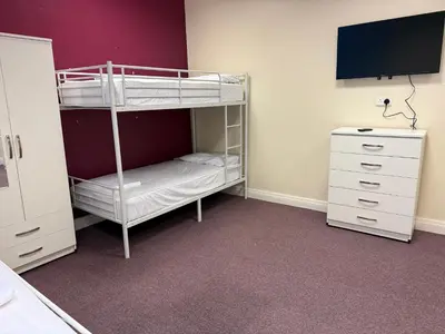 a bedroom with a bunk bed with a tv and a dresser at Art Group Apartments in Fleetwood