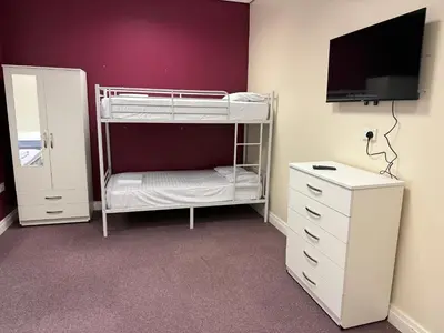 a bedroom with a bunk bed with a tv and a dresser at Art Group Apartments in Fleetwood