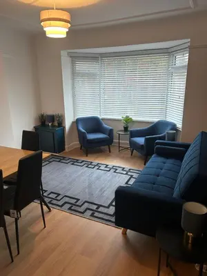 a living room with a blue couch and chairs and a table at Cosy Apartment in Wallasey Village Near Liverpool in Wallasey