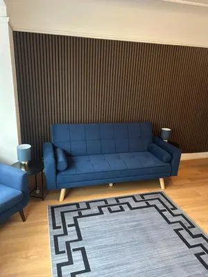 a living room with a blue couch and a rug at Cosy Apartment in Wallasey Village Near Liverpool in Wallasey