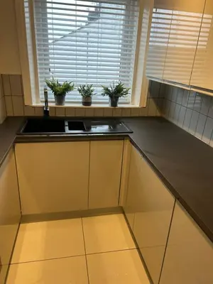 a kitchen with a sink and a window with potted plants at Cosy Apartment in Wallasey Village Near Liverpool in Wallasey