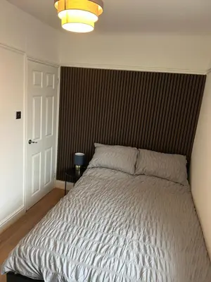 a bedroom with a large bed with a brown headboard at Cosy Apartment in Wallasey Village Near Liverpool in Wallasey