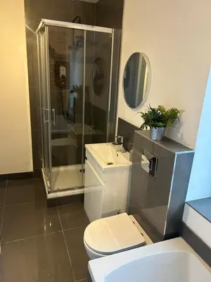 a bathroom with a shower and a toilet and a sink at Cosy Apartment in Wallasey Village Near Liverpool in Wallasey
