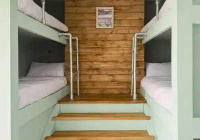 two bunk beds in a room with stairs at Pitchside Place Walk to Anfield sleeps 19 in Liverpool